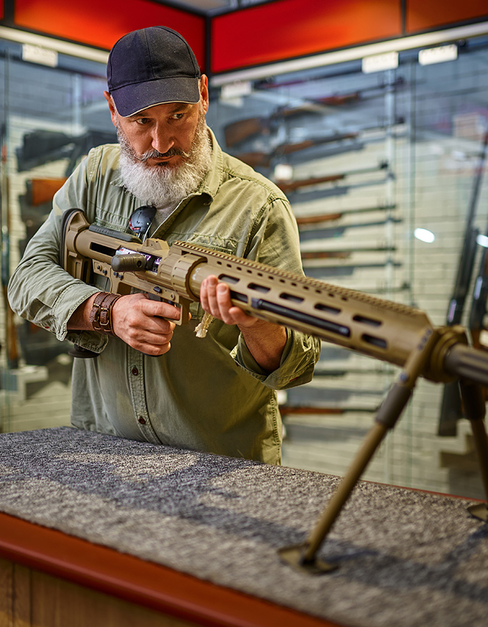 bearded man reload powerful rifle in gun store QGHAB8Y